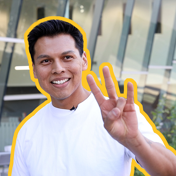 A man in a white shirt shows the pitchfork with his fingers. 