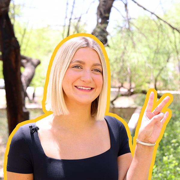 A woman in a black shirt shows the pitchfork with her fingers. 