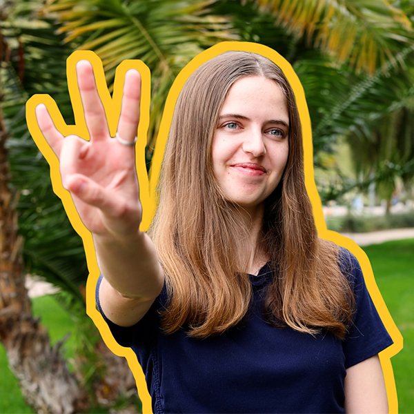 A female student in a navy short shows the pitchfork with her fingers. 