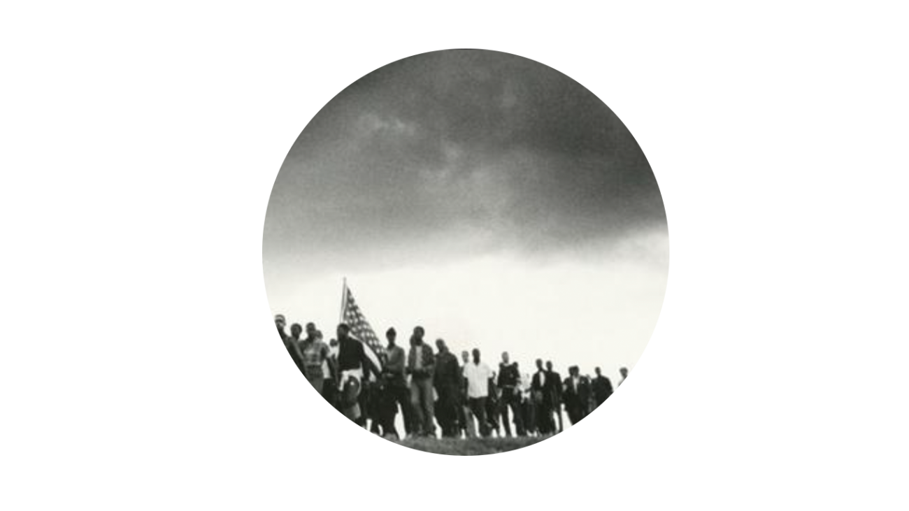 Black and white photo of men marching with American flags.