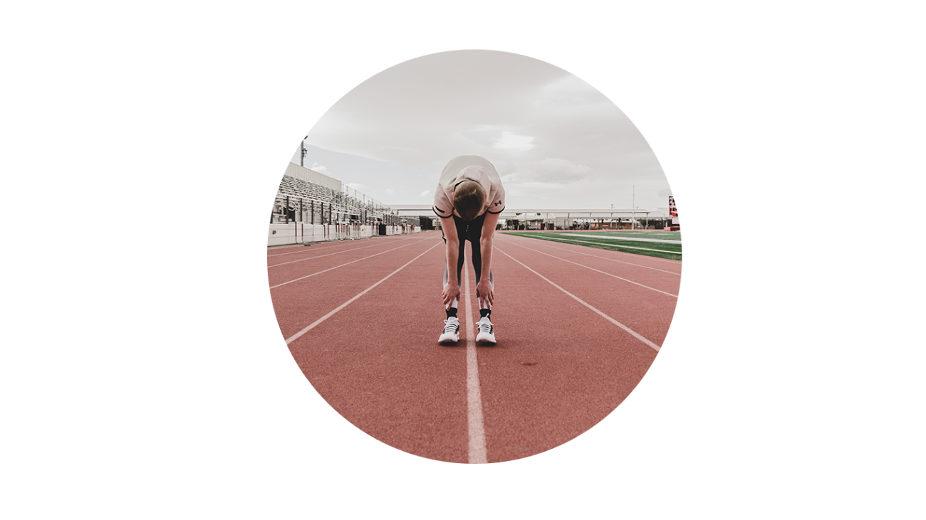 High school student stretches before a track meet.